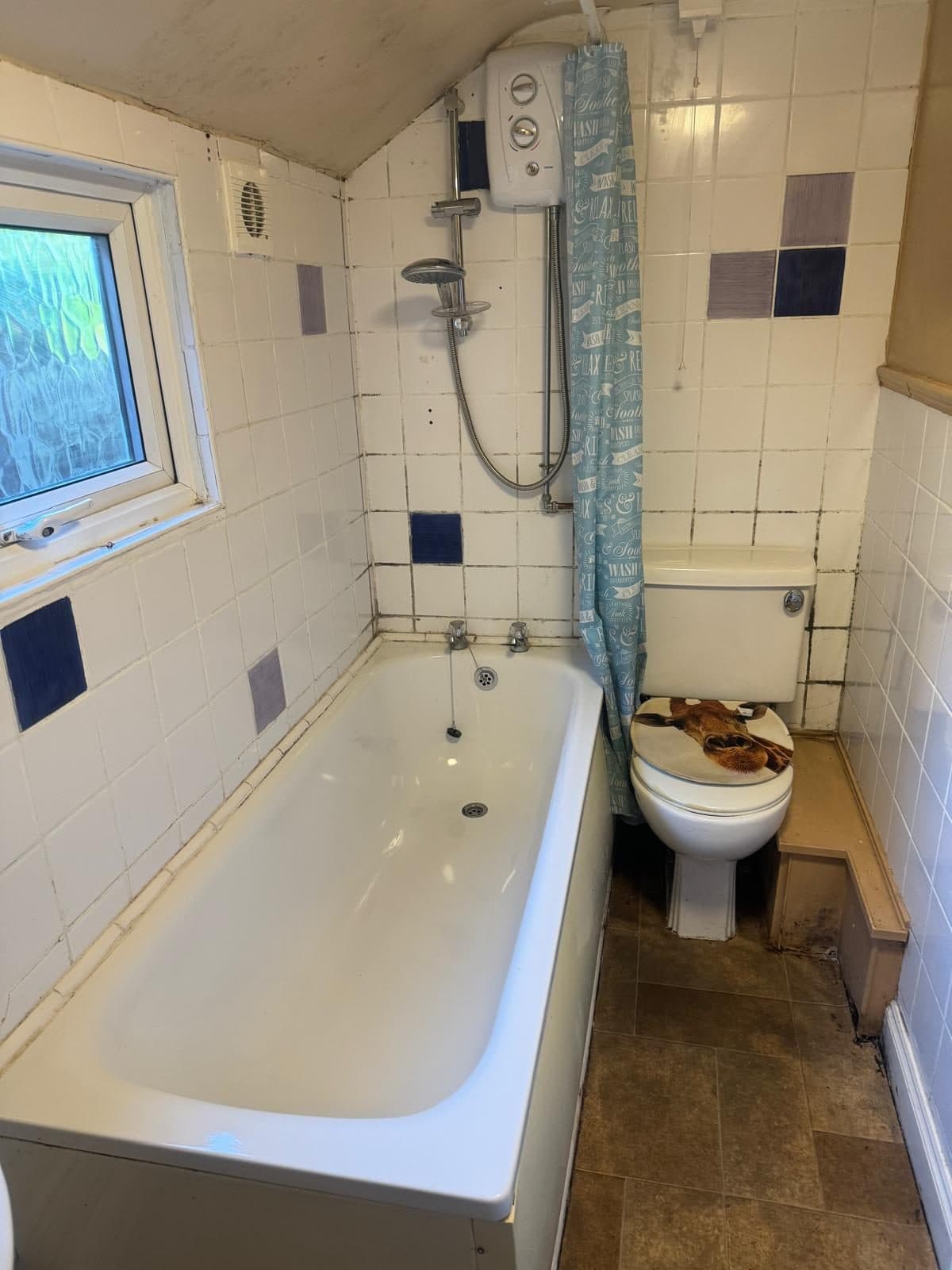 The same bathroom after cleaning: bright bath, clean tiles and floor